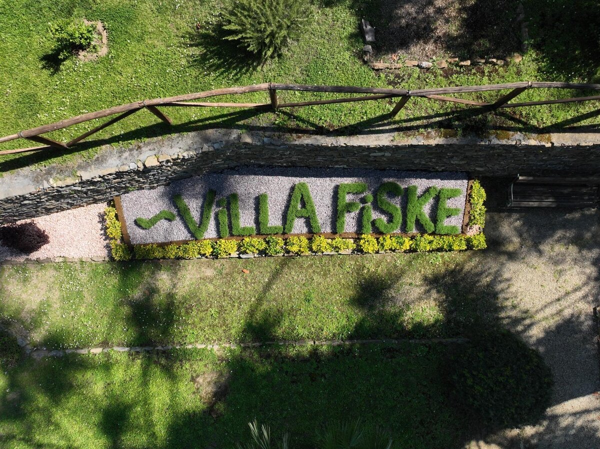 'Villa Fiske' Schriftzug aus Hecken in einem Garten von oben gesehen