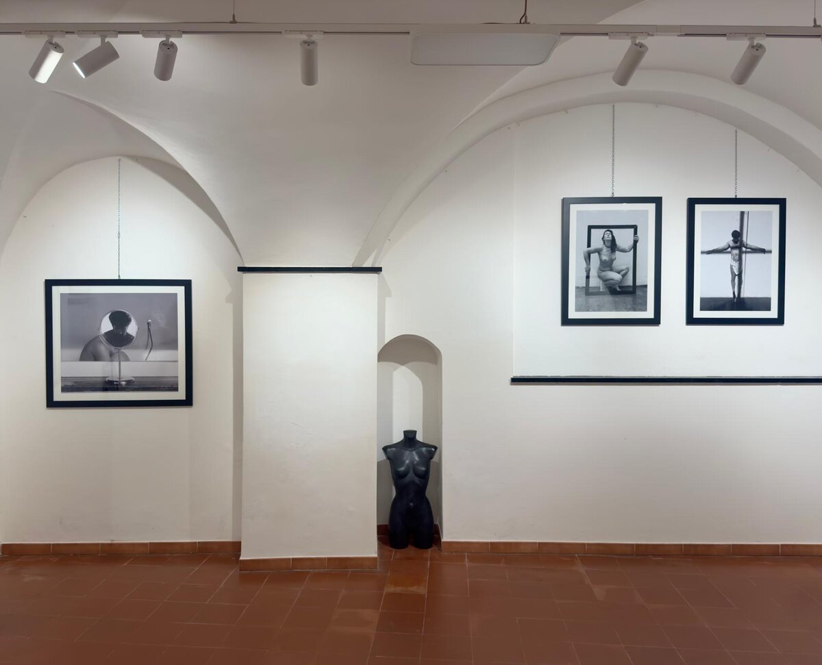 Inside an art gallery with black and white photos and a black mannequin.